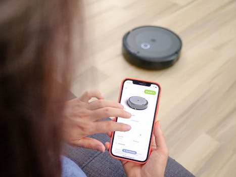 pexels-photo-8566439-8566439 Person using smartphone app to remotely control a robotic vacuum cleaner.